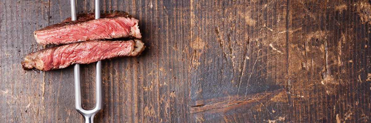 Steak cooked medium rare on a wooden board