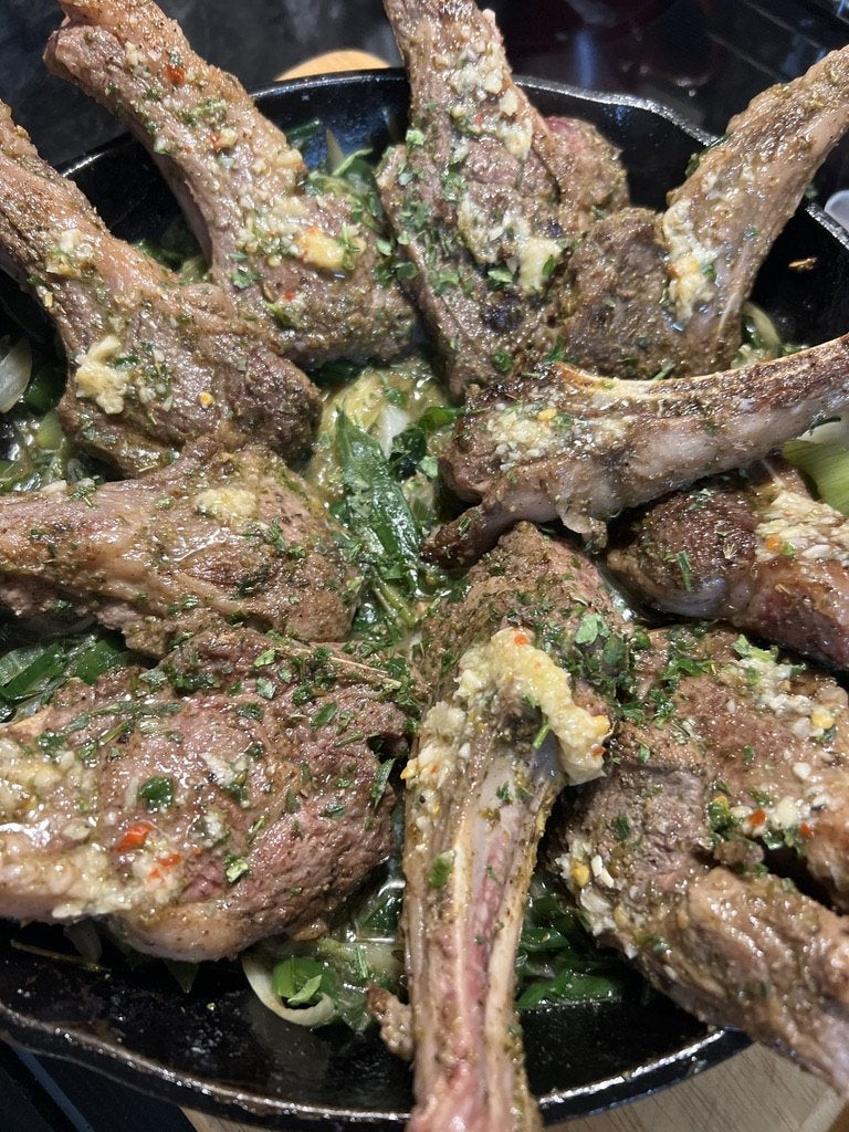 Herb-crusted lamb chops in a cast iron skillet