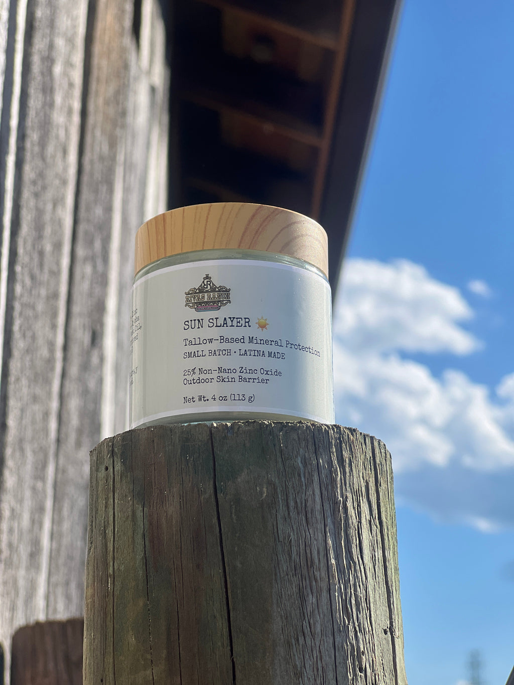 Front of Sun Slayer Mineral Tallow Sun Balm jar outdoors on the ranch