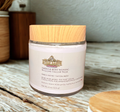 Jar of Vanilla Mint Revival whipped tallow balm with wooden lid on a wooden surface