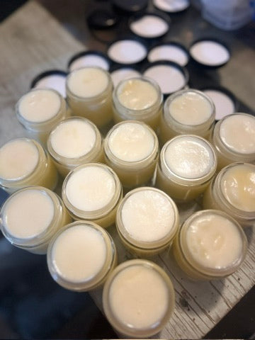 Open jars of Breathe Easy Aromatic Chest Balm on a wooden surface
